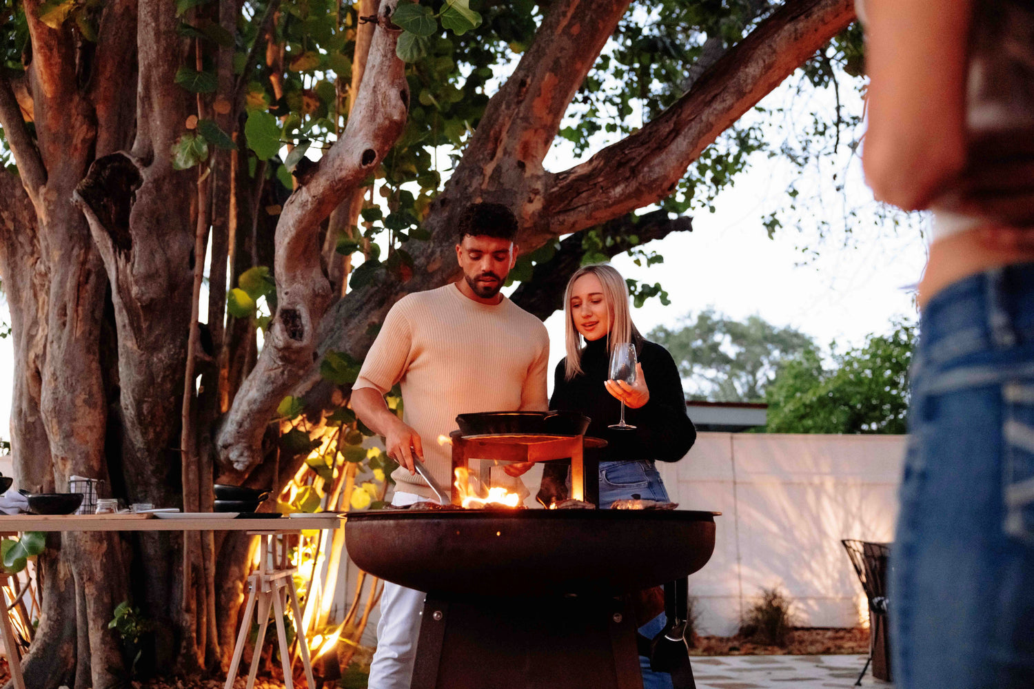 Couple joyfully cooking together on the Unifire, preparing a meal on its versatile cooking surface.